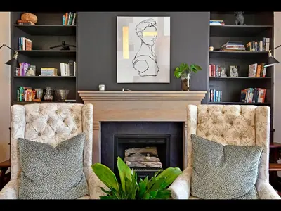 a living room with two chairs and a fireplace at Ashbourne Boutique Guest House in Franschhoek
