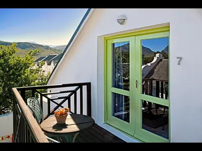 a green door and a table on a balcony at Ashbourne Boutique Guest House in Franschhoek