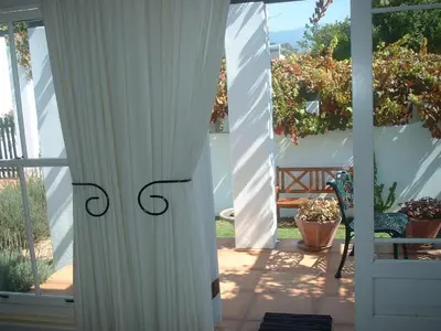 an open door to a patio with a white curtain at Sunny Lane in Franschhoek