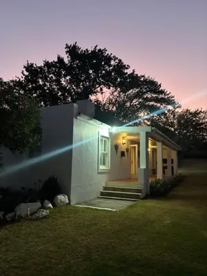 a small white house with a light on it at Cottage at Kanu Wines in Cape Town
