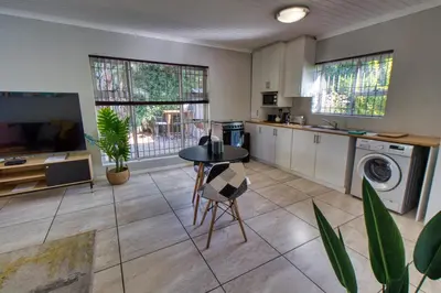 a kitchen with a table and a laundry room at Magnificent Apartment in Cape Town