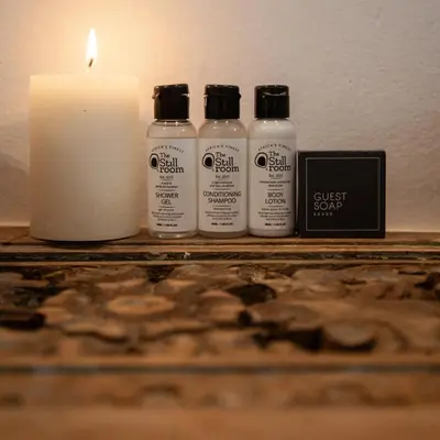 four bottles of essential oils next to a candle at Ayama Wine Farm - Manor House in Wellington