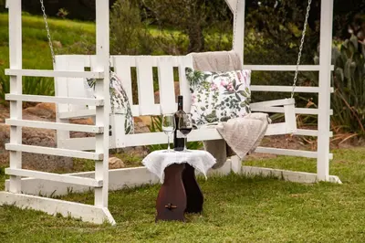 a bottle of wine sitting next to a swing at Ayama Wine Farm - Manor House in Wellington