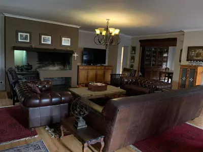 a living room with leather furniture and a chandelier at 5 BEDROOM CAPE TOWN FAMILY HOME PET FRIENDLY in Cape Town