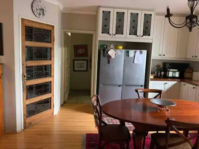 a kitchen with a table and a refrigerator at 5 BEDROOM CAPE TOWN FAMILY HOME PET FRIENDLY in Cape Town