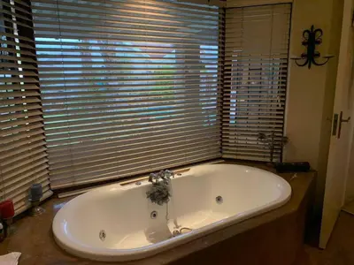 a bath tub in a bathroom with a large window at 5 BEDROOM CAPE TOWN FAMILY HOME PET FRIENDLY in Cape Town