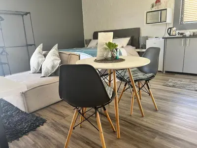 a room with a table and chairs and a bed at The Charming Place in Cape Town