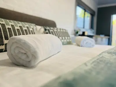 a stack of towels on top of a bed at The Charming Place in Cape Town