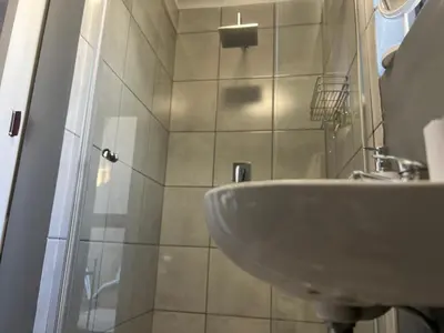a bathroom with a sink and a shower at The Charming Place in Cape Town