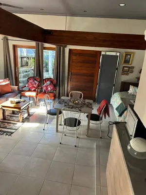 a living room with a table and chairs at Mabel View in Cape Town