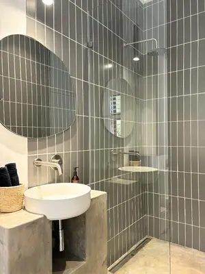 a bathroom with a sink and a glass shower at The Paarl Grand in Paarl