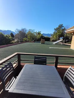 a table and two chairs on a tennis court at Elegantie Apartment Protea 5 Lovell Avenue in Stellenbosch