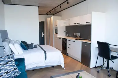 a small bedroom with a bed and a kitchen at 101 Bridgewater Apartment in Cape Town
