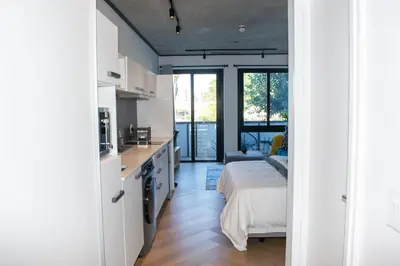 a kitchen and living room with a bed in a room at 101 Bridgewater Apartment in Cape Town