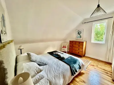 a bedroom with a bed and a dresser and a window at Tranquility in Hermanus