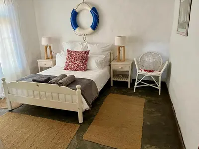 a bedroom with a bed with a mirror on the wall at Tranquility in Hermanus