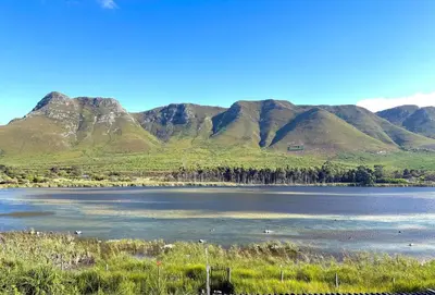 a large body of water with mountains in the background at Tranquility in Hermanus