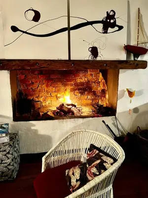 a fireplace in a living room with a wicker basket at Tranquility in Hermanus