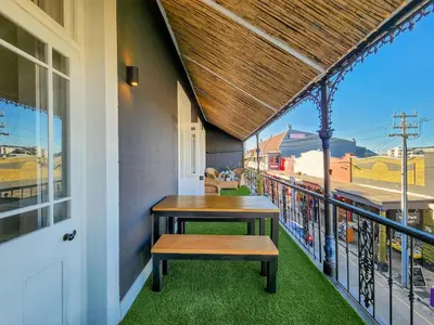 a porch with a bench on a balcony at Obs Loft Apartments Observatory in Cape Town