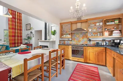 a kitchen with a table and chairs and a stove at Sunset Yellow Cottage in Cape Town