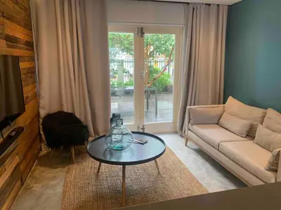 a living room with a couch and a table at Well Appointed Apartment by ARPA Hospitalities in Stellenbosch