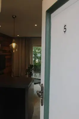 a door leading into a living room with a kitchen at Well Appointed Apartment by ARPA Hospitalities in Stellenbosch