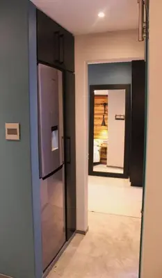 a kitchen with a refrigerator and a hallway at Well Appointed Apartment by ARPA Hospitalities in Stellenbosch
