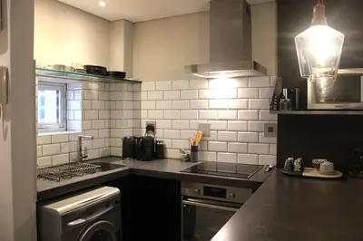 a kitchen with a sink and a stove at Well Appointed Apartment by ARPA Hospitalities in Stellenbosch