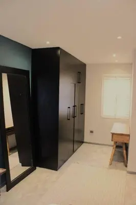 a black refrigerator in a room with a window at Well Appointed Apartment by ARPA Hospitalities in Stellenbosch