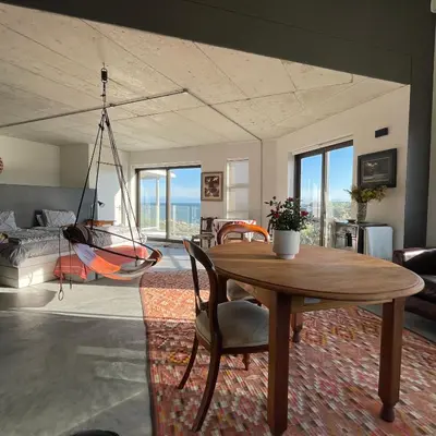 a living room with a table and a hammock at Suikerbos in Pringle in Pringle Bay
