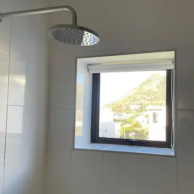a bathroom with a window and a shower at Suikerbos in Pringle in Pringle Bay