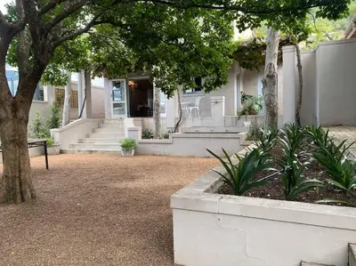 a house with a porch and stairs in front of it at Auret Street Garden Cottage in Paarl