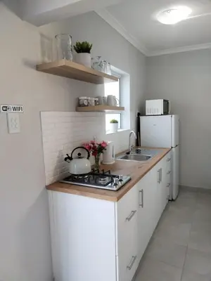 a kitchen with a stove and a white refrigerator at Harmonie Self Catering in Wolseley