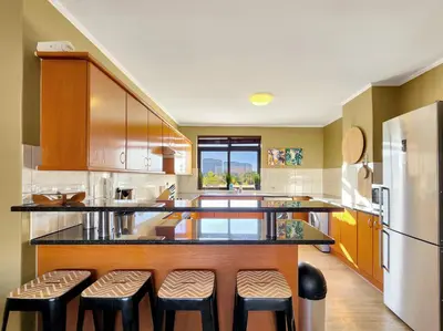 a large kitchen with a counter and stools at Family-Friendly Home with Ample Space in Cape Town