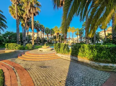 a walkway with a fountain and palm trees in a park at Family-Friendly Home with Ample Space in Cape Town