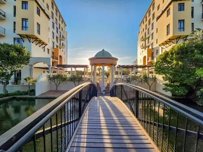 a bridge over a river with a gazebo between buildings at Family-Friendly Home with Ample Space in Cape Town