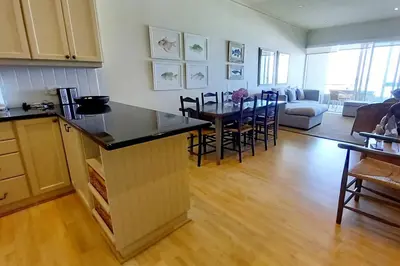 a kitchen and living room with a table and chairs at 305B Bayview Breathe in Hermanus