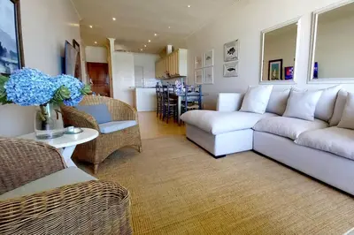 a living room with a couch and chairs and a table at 305B Bayview Breathe in Hermanus