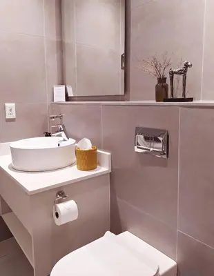 a bathroom with a sink and a toilet and a mirror at Apartment at Hermanus Waterfront in Hermanus
