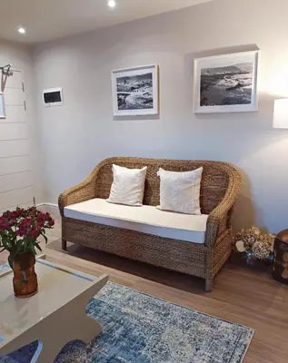 a wicker couch sitting in a living room at Apartment at Hermanus Waterfront in Hermanus
