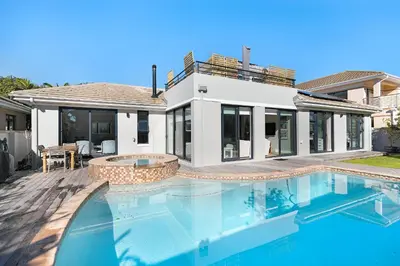 a house with a swimming pool in front of a house at Sunset Villa 50 in Cape Town