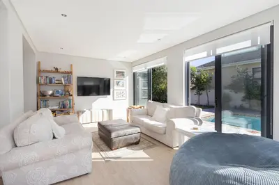 a living room with white furniture and a pool at Sunset Villa 50 in Cape Town