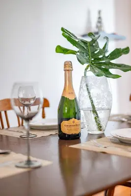 a bottle of wine sitting on a table with a glass at Enchanting Abode in Rosebank in Cape Town