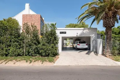 a white car parked in a garage with a palm tree at Serendipite Villa in Franschhoek