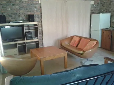 a living room with a couch and a chair and a table at Little Lotta Cottage in Caledon
