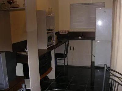 a kitchen with a refrigerator and a table with a microwave at Little Lotta Cottage in Caledon