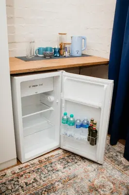 an open refrigerator with bottles of water in it at Mooi Uitsig Lodge in Paarl