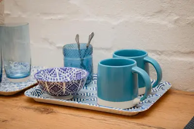 a tray with blue cups and bowls on a table at Mooi Uitsig Lodge in Paarl