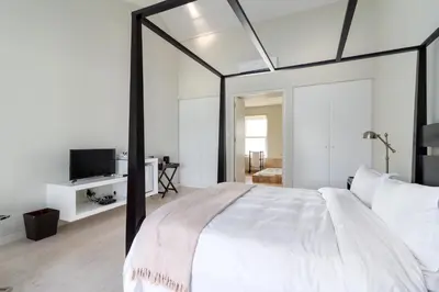 a bedroom with a large bed with a large mirror at La Terra de Luc in Franschhoek
