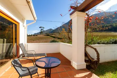 a patio with a table and chairs and a view at La Terra de Luc in Franschhoek